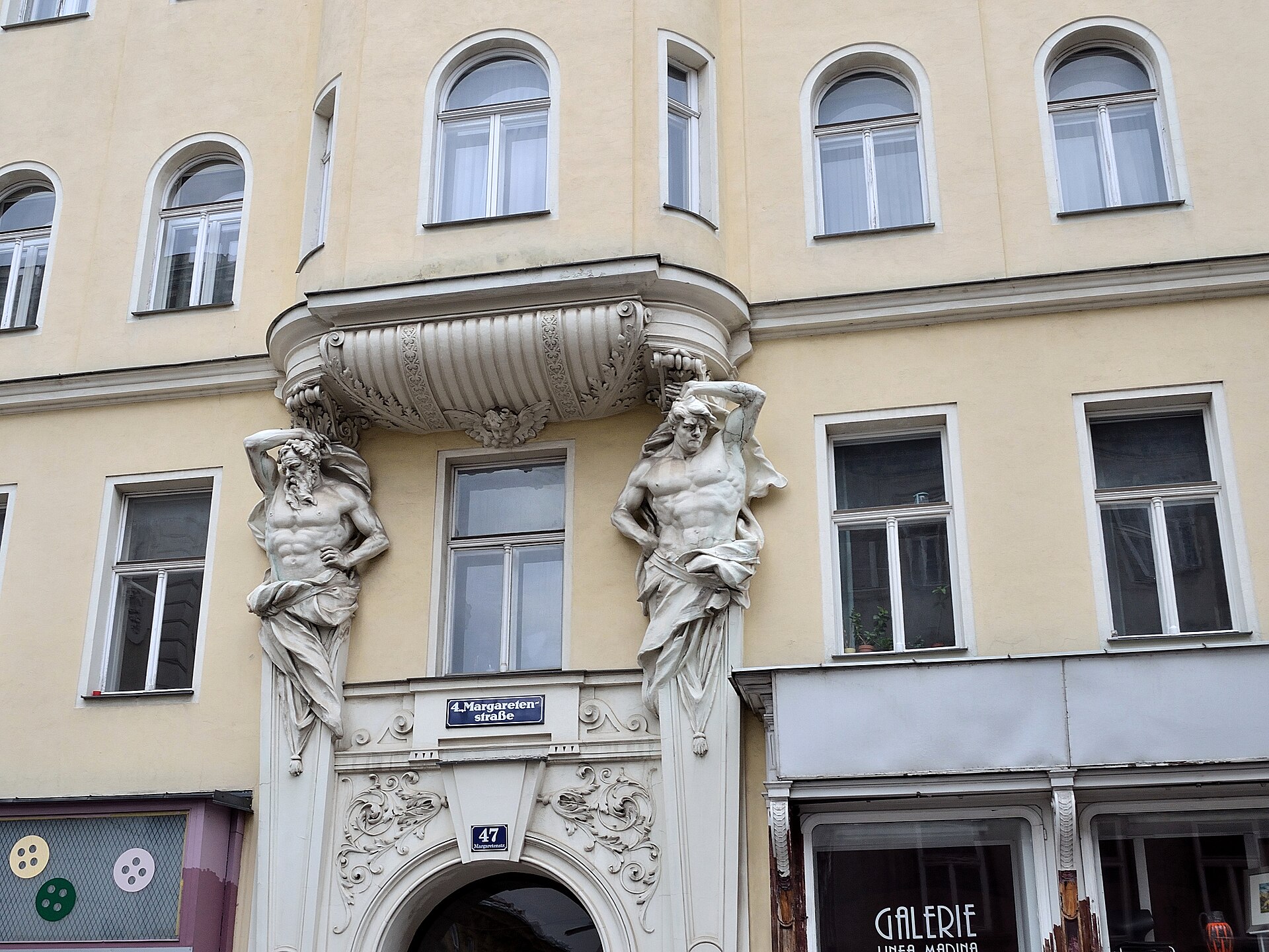 Sculpted atlantes supporting a balcony on a Vienna Altbau façade, Margaretenstraße